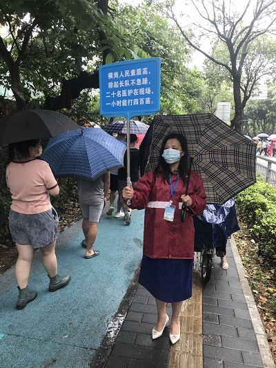 儀春霞在雨中引導(dǎo)居民有序接種疫苗.jpg